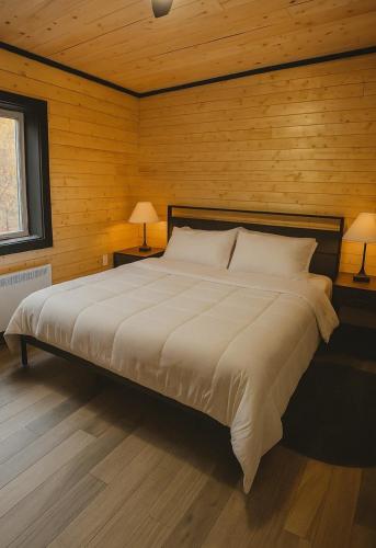 una camera da letto con un grande letto e pareti in legno di All About ME Loft a Montague
