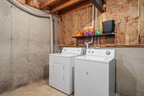 a laundry room with two washing machines and a tv at New Spacious Renovated Townhouse in Spring Hill