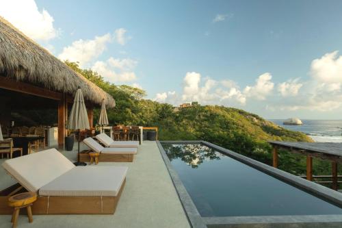 a villa with a swimming pool and a view of the ocean at Casa Yute Boutique Hotel Playa Aragon in San Agustinillo
