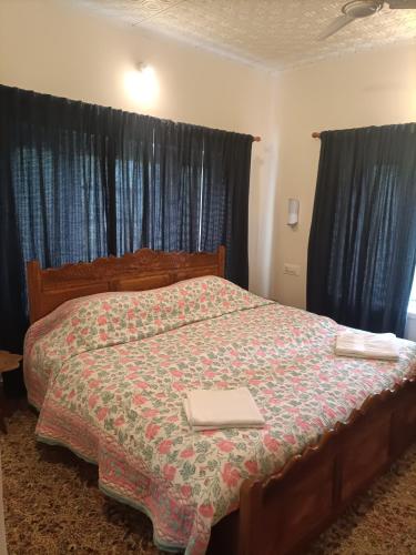 a bedroom with a bed with a blanket on it at Snow Leopard Lodge in Srinagar