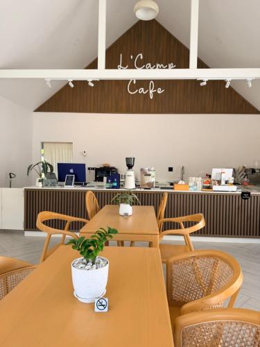a restaurant with wooden tables and chairs and a counter at L'camp and cafe' Kohchang in Trat