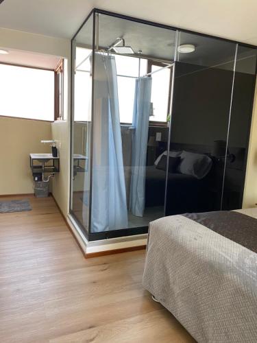 a bedroom with a large glass room with a bed at Villa San José in Arequipa