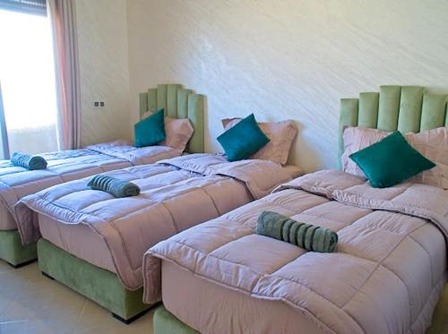 a group of three beds in a room at Imsouane Wave Residences in Imsouane