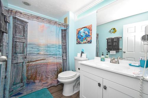 a bathroom with a toilet and a shower curtain at Cedar Key Islands Dolphins Cay Condo in Cedar Key