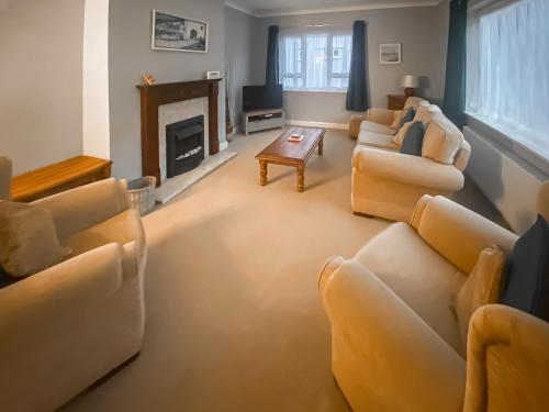 a living room with couches and a fireplace at Sea View Cottage in Rhos-on-Sea