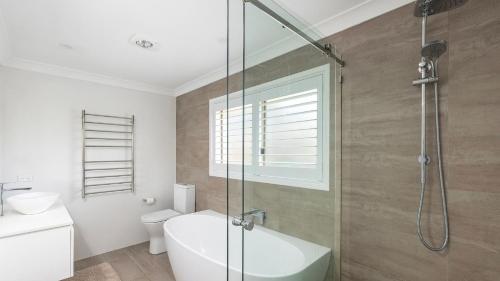 a bathroom with a shower and a toilet and a sink at Serenity in Corlette