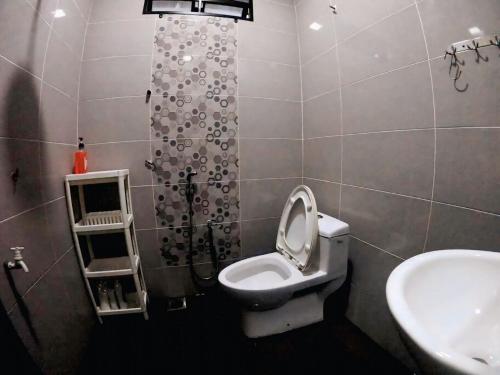 a bathroom with a toilet and a sink at Sweethome MAMA in Kuala Terengganu