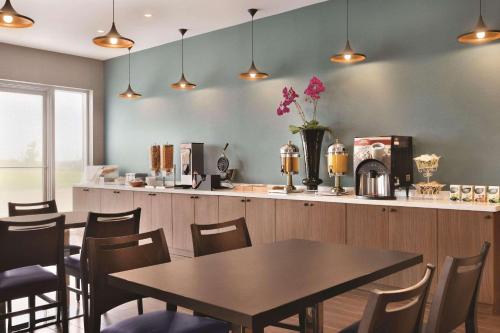 a restaurant with a table and chairs and a counter at Park Inn by Radisson Brampton, ON in Brampton