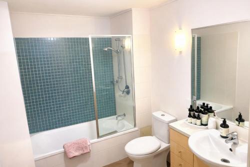 a bathroom with a shower and a toilet and a sink at Large Family Sized Unit with Watersports, Maroochy River, Lagoon, and Beach Access in Twin Waters