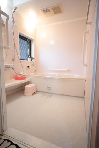 a small white bathroom with a sink and a shower at Oyadoya Nagakute 一軒貸切 ジブリ直結駅徒歩1分 BBQ常設 駐車場3台 in Owariasahi