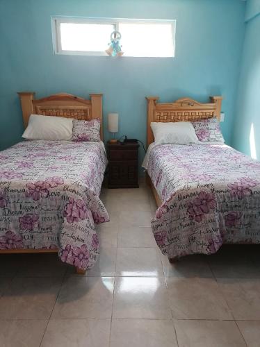 a bedroom with two beds and a window at Casa Quiroga in Mexico City