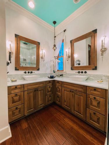 a bathroom with two sinks and two mirrors at de la Bleau B&B in Mandeville