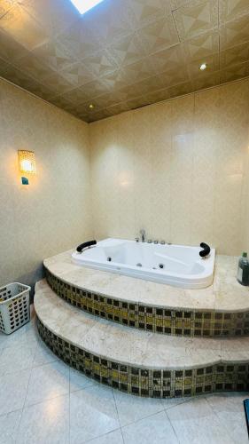 a bathroom with a bath tub in a room at Suite Room with big balcony in Al Rahba