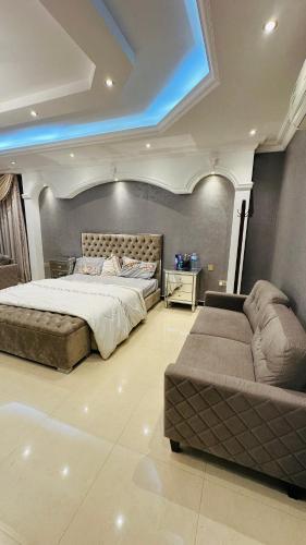 a large bedroom with a bed and a couch at Suite Room with big balcony in Al Rahba