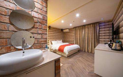 a bathroom with a sink and a bed in a room at R Hotel in Bucheon
