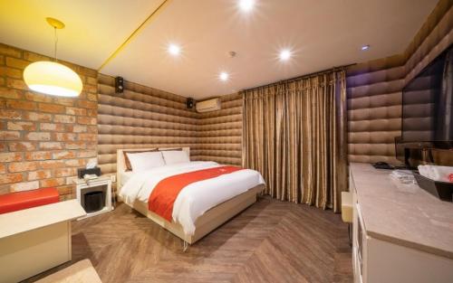 a bedroom with a bed and a brick wall at R Hotel in Bucheon