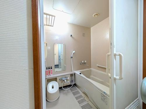 a bathroom with a tub and a sink and a toilet at Suizenji Comfort Hotel in Kumamoto