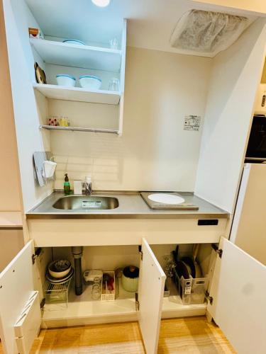 a small kitchen with a sink and a counter at Private Room near Iriya in Tokyo