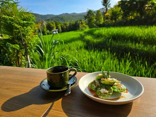 a plate of food and a cup of coffee on a table at Umaku Bali Homestay in Munduk