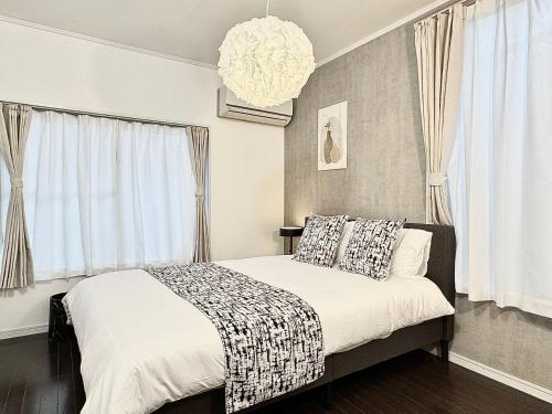 a bedroom with a bed and a chandelier at Higashirokugō, Ota City -3LDK house-OT0493 in Tokyo