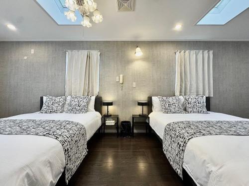 two beds in a hotel room with white sheets at Higashirokugō, Ota City -3LDK house-OT0493 in Tokyo