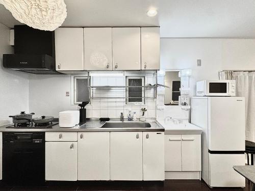 a white kitchen with a sink and a refrigerator at Higashirokugō, Ota City -3LDK house-OT0493 in Tokyo