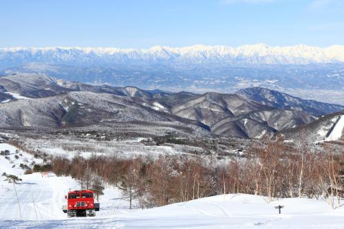 a red truck driving down a snow covered mountain at Bouzantei Kotobuki in Ueda