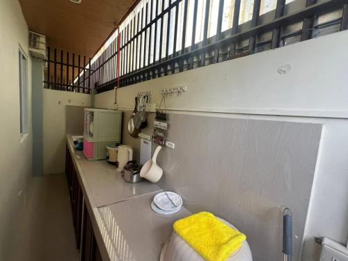 a kitchen with a counter with a yellow towel on it at Westlinehomestay in Puerto Princesa City
