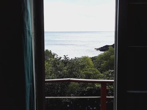 a view of the ocean from a window at Adega Ramalho in Canto da Areia