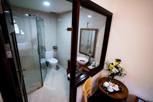 a bathroom with a toilet and a sink and a mirror at Vela Phu Quoc Resort in Phú Quốc