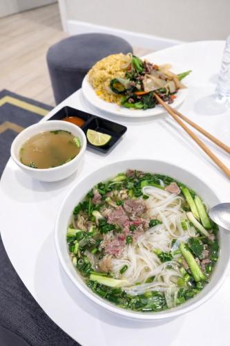 a table with two plates of food and a bowl of soup at Pan House in Hanoi