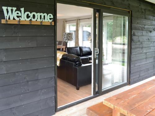 a sliding glass door to a living room with a couch at Larch Lodge in Bentley