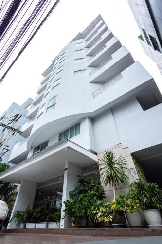 a white building with potted plants in front of it at Club Mahindra Mac Boutique Hotel in Bangkok