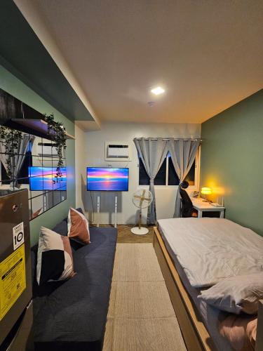 a bedroom with a bed and a flat screen tv at Your Cozy Space in Stanford Suites 3 Brgy Inchican Silang Cavite in Silang