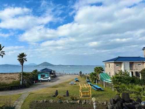 a view of a beach with a house and the ocean at Udo Daol Pension in Jeju