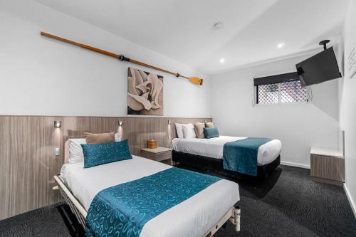 a hotel room with two beds and a flat screen tv at North Adelaide Boutique Stays Accommodation in Adelaide