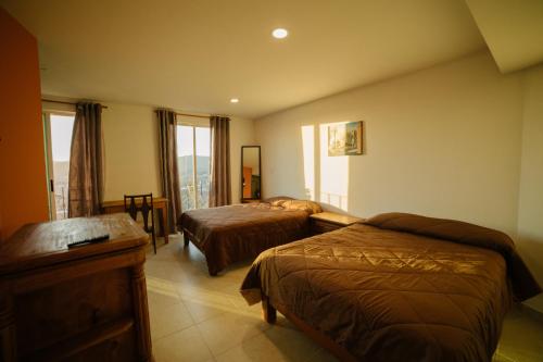 a hotel room with two beds and a window at Casa del Pintor Guesthouse in Guanajuato