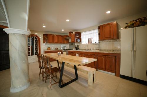 a kitchen with a wooden table and a refrigerator at Casa del Pintor Guesthouse in Guanajuato