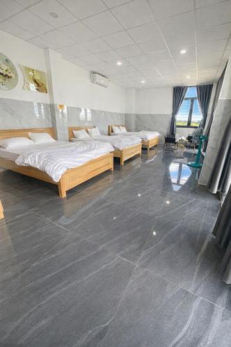 a room with three beds in a room at Ánh Mai Hotel in Bảo Lộc