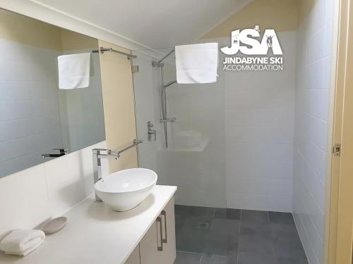 a white bathroom with a sink and a shower at Parkwood 7 in Jindabyne