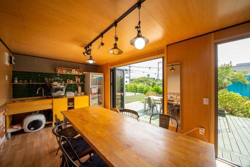 a kitchen with a wooden table and a dining room at Jeju Aromtarom House in Jeju