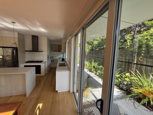 an open kitchen and living room with sliding glass doors at Cowes Central Beach Villa II in Cowes