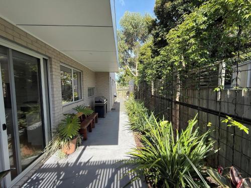 a porch of a house with benches and a fence at Cowes Central Beach Villa II in Cowes