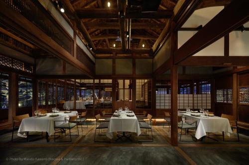 a restaurant with white tables and chairs and windows at LOQUAT西伊豆 in Izu