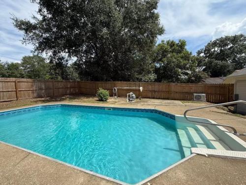 a swimming pool in a backyard with a fence at Spacious 4BR Home Pool and Comfort in Columbus