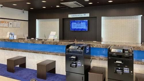 two atm machines in a lobby with a counter at Toyoko Inn Shin takaoka eki Shinkansen Minami guchi in Takaoka