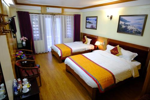 a hotel room with two beds and a television at Hotel Sao Xanh in Sapa