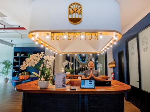 a man standing at a bar in a store at Secana Beachtown Resort & Villas in Canggu