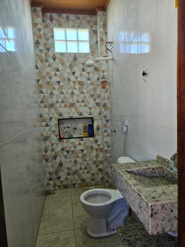 a bathroom with a toilet and a fireplace at Cantinho das Joaninhas in Prado
