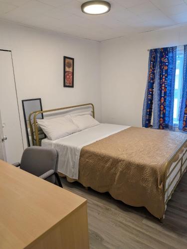 a bedroom with a bed and a chair and a table at Motel LA RÉFÉRENCE in Trois-Rivières